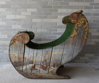 A hand painted Dutch wooden child's push sled, either for snow or ice, decorated with winter