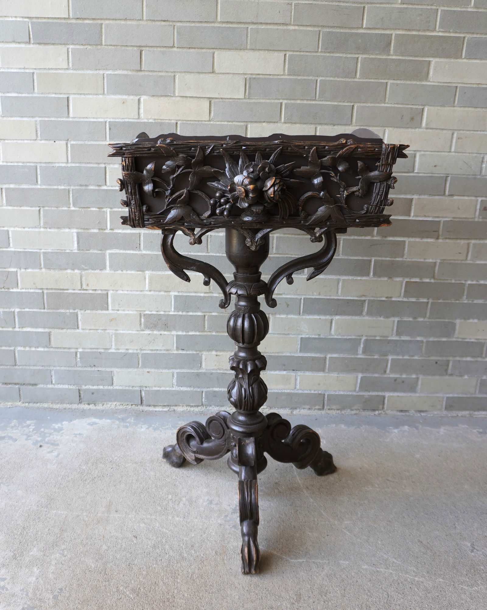 A Black Forest style rustic Victorian planter with newer sheet steel insert, circa 1875. The: A Black Forest style rustic Victorian planter with newer sheet steel insert, circa 1875. The planter, with hand carved flowers mounted on a carved wooden pedestal leading to 3 scrolled legs terminatin
