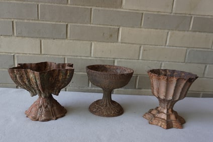 Three small cast iron table top flower urns. The largest is star shaped, and measures 8 1/2"