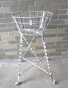 A Victorian wire sewing basket (or plant stand) on wrought iron stand with twisted legs leading to