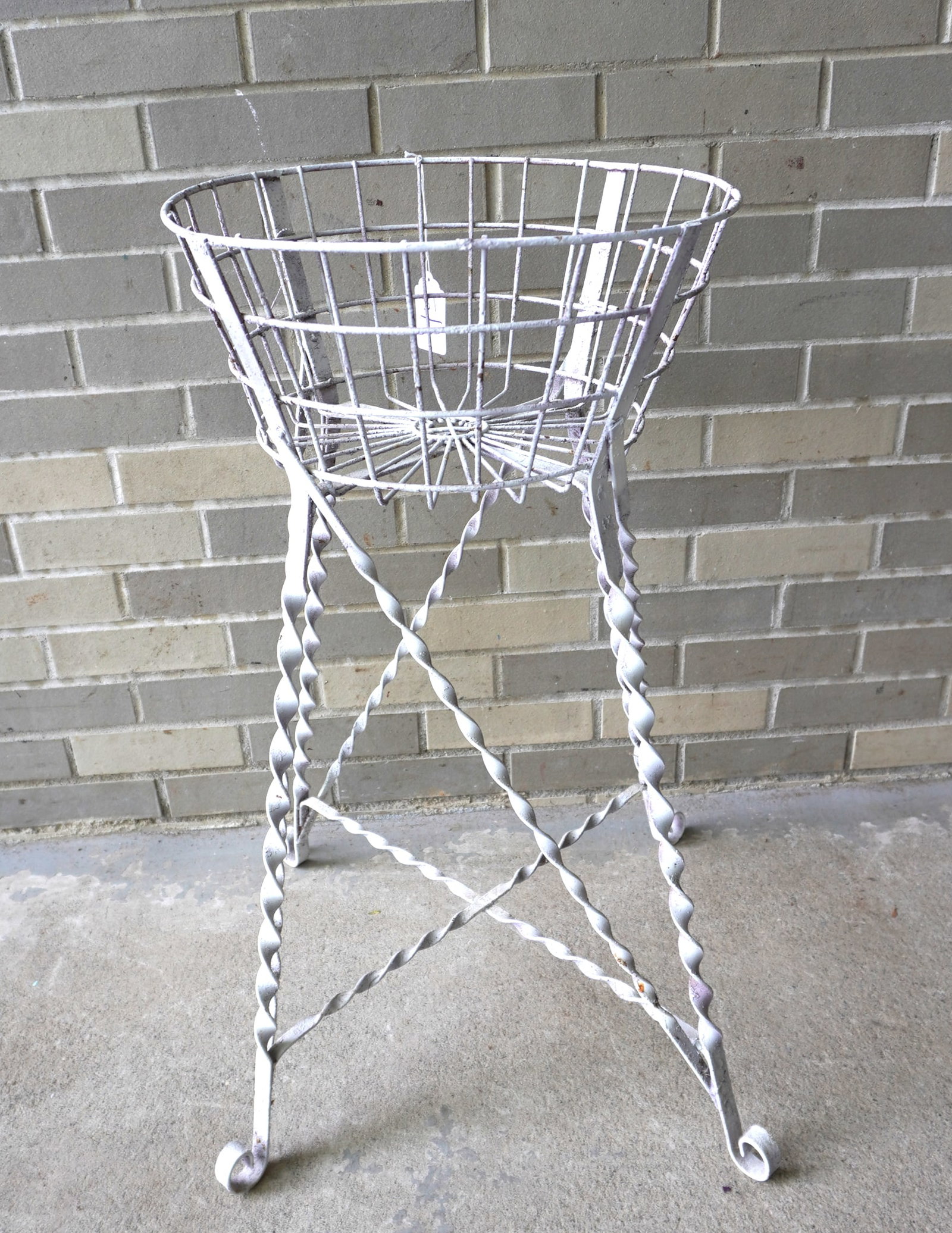 A Victorian wire sewing basket (or plant stand) on wrought iron stand with twisted legs leading to: A Victorian wire sewing basket (or plant stand) on wrought iron stand with twisted legs leading to scrolled feet, late 19th century. Good condition. The basket 16" diameter x 7 3/4"H - the entire stan