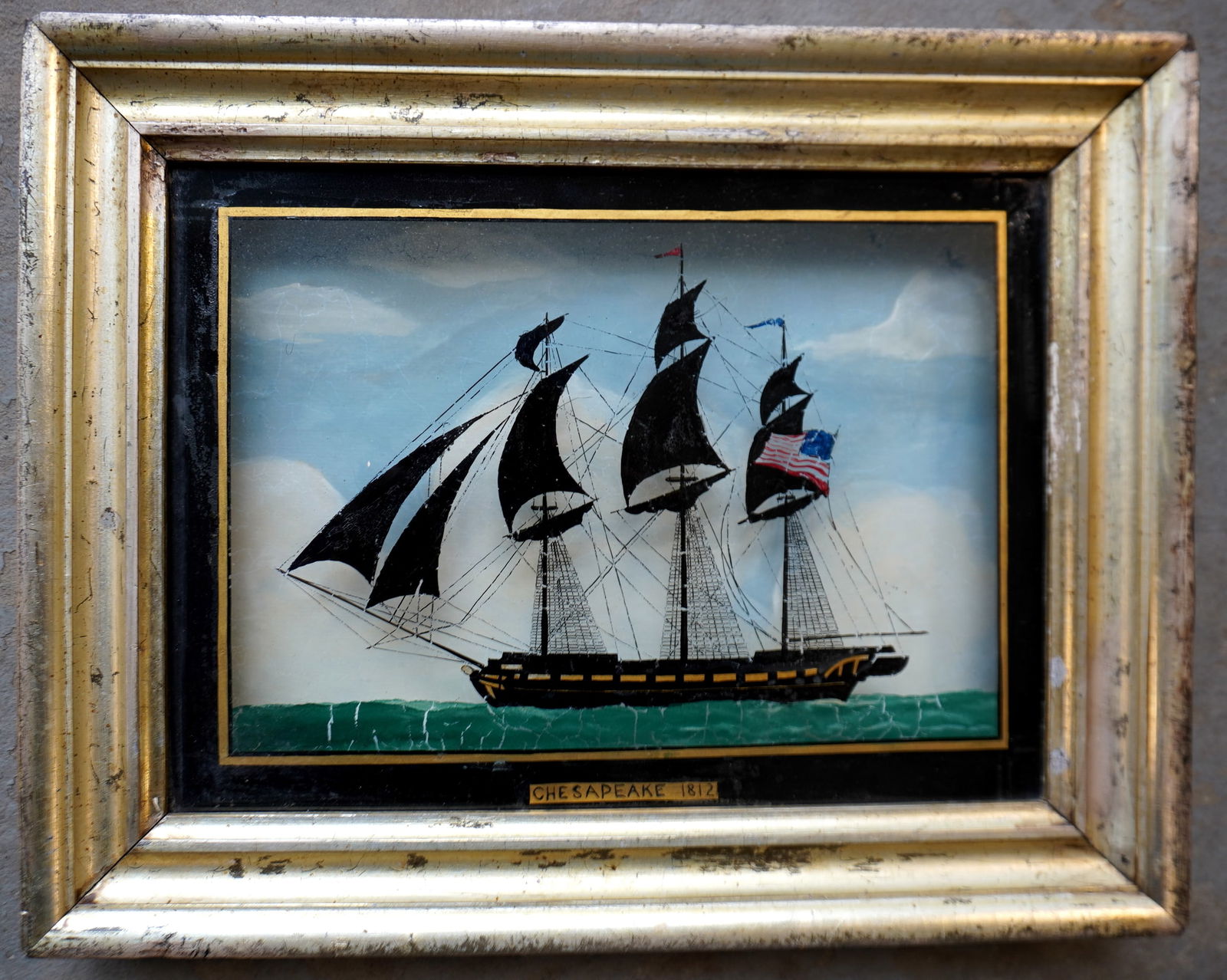 A reverse painting on glass of American frigate USS Chesapeake. used in the Revolutionary War -: A reverse painting on glass of American frigate USS Chesapeake. used in the Revolutionary War - signed bottom center "Chesapeake 1812". Original shadowbox lemon gold frame with watercolor background.