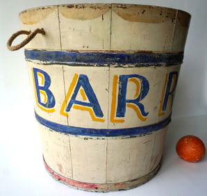 A colorful hand painted circus animal feed bucket with rope handles, marked with shadow lettering