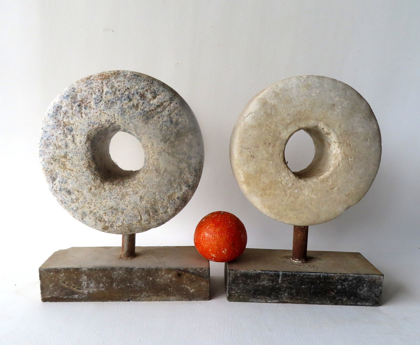 Two very early mill stones, 18th century. Each mounted on museum stand for display purposes. The: Two very early mill stones, 18th century. Each mounted on museum stand for display purposes. The largest (stone only) 8 3/4" diameter - size on base 12 1/4"H x 9 1/8"W x 3 1/2"D. Provenance: From the 