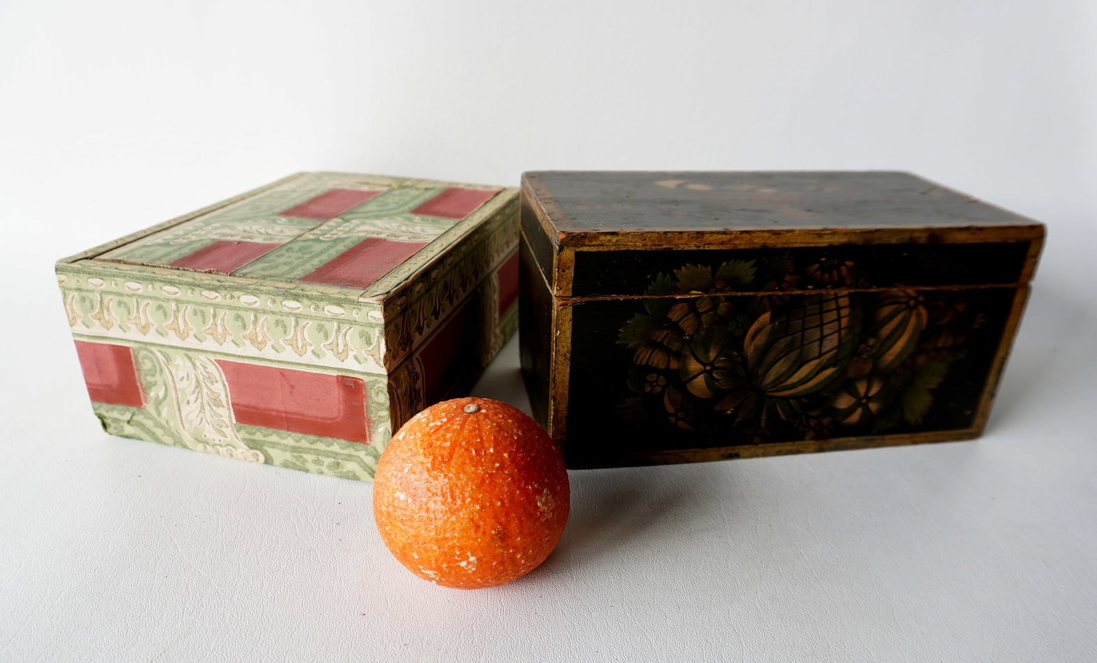 Two small primitive wooden boxes. The first, a document box, stenciled and painted on all sides: Two small primitive wooden boxes. The first, a document box, stenciled and painted on all sides including a lid decorated with a bowl of fruit, and having gold borders throughout, good condition, circ