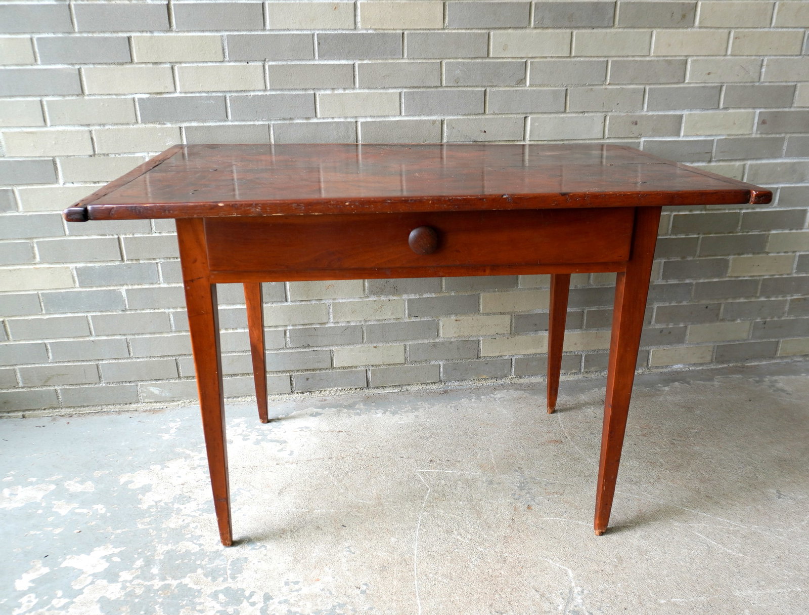 An early cherry tavern table with single drawer and tapered legs - the top with breadboard ends.: An early cherry tavern table with single drawer and tapered legs - the top with breadboard ends. Typical use wear and overall good condition. Late 18th to early 19th century. Measures 44"W x 28"D x 28