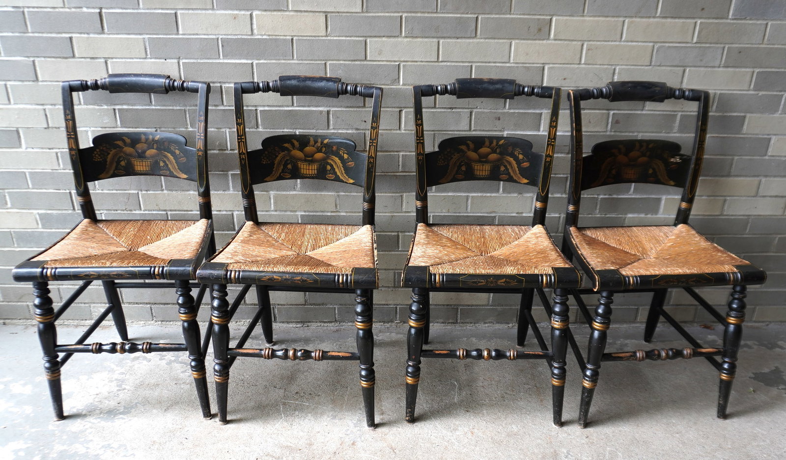 A set of 4 Hitchcock country chairs with original paint and stenciling, all having rush seats. Each: A set of 4 Hitchcock country chairs with original paint and stenciling, all having rush seats. Each signed "L. Hitchcock. Hitchcocksville Conn. Warranted.". All in good condition. Circa mid 20th centu