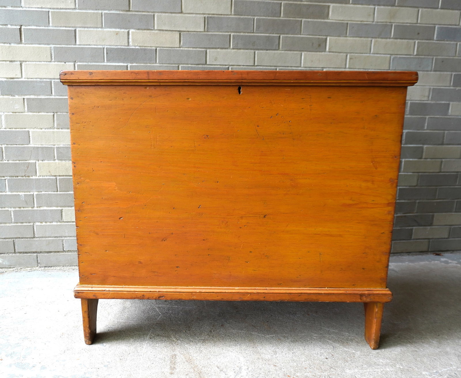 A primitive blanket box with deep well in original yellow paint, with half-moon cutouts on sides and: A primitive blanket box with deep well in original yellow paint, with half-moon cutouts on sides and molded front apron. Missing the drawer below the interior till, otherwise very good condition. Earl