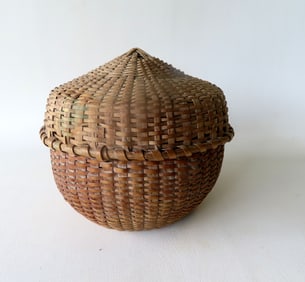 An unusual sewing basket with intricate weaving to create a peaked top to lid, pushed up bottom and