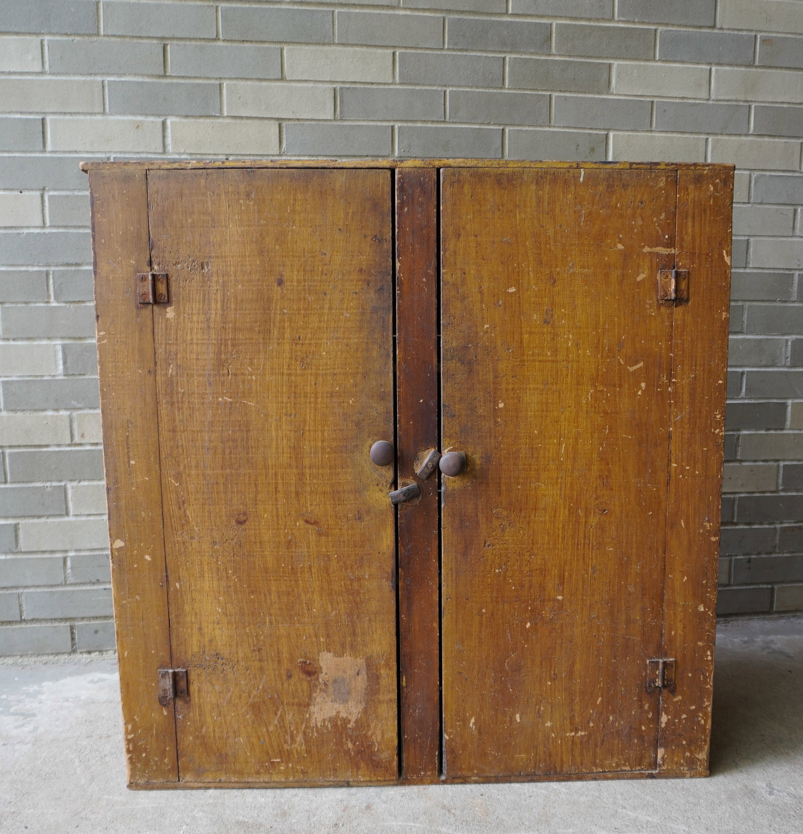 A small 2 door floor cupboard in original paint. The top in yellow and the sides and both doors in: A small 2 door floor cupboard in original paint. The top in yellow and the sides and both doors in brown and yellow grain paint. The interior doors in old whitewash paint. Typical use wear and overall