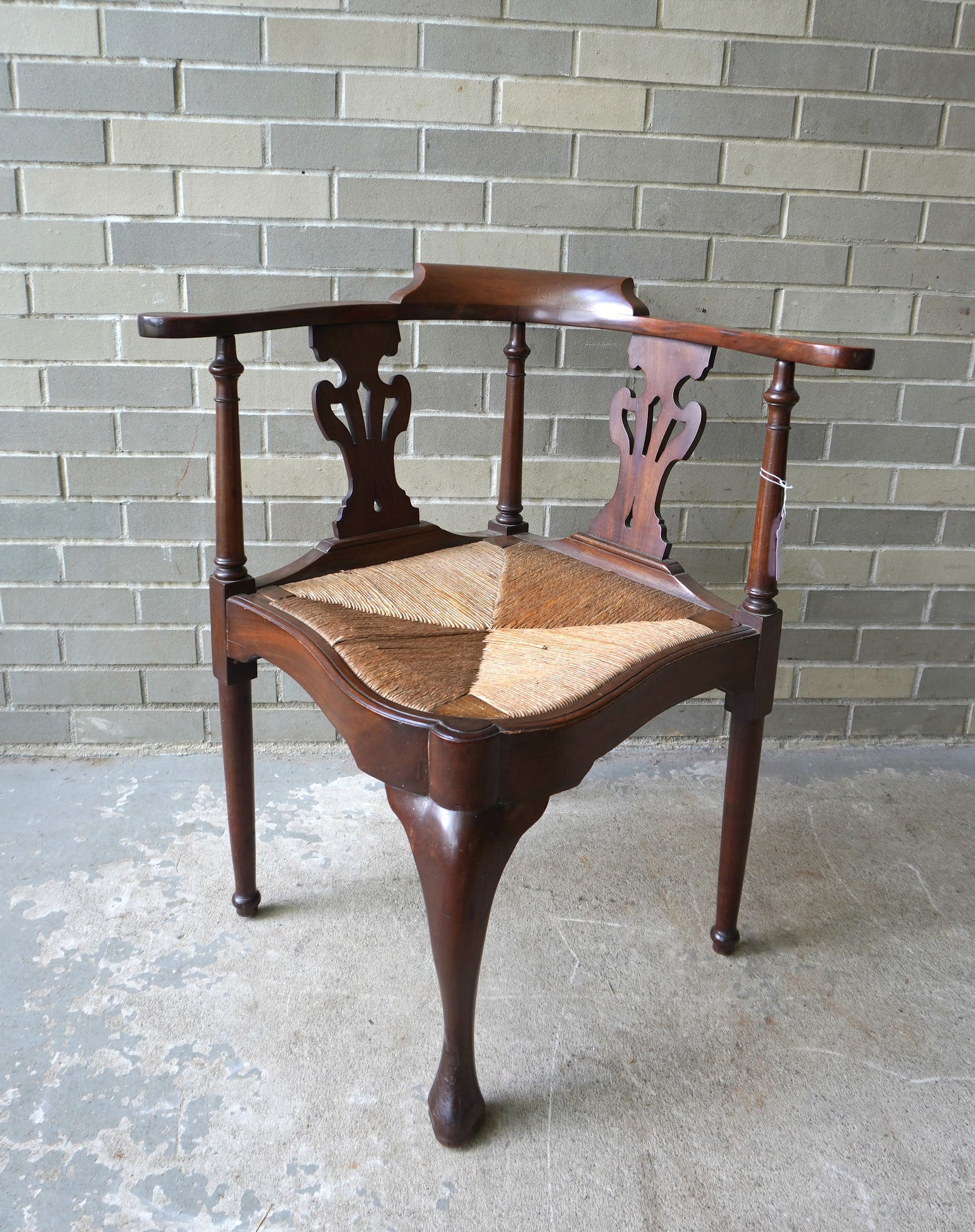 A Centennial Queen Ann style mahogany corner chair with removable fitted rush seat, 2 pierced back: A Centennial Queen Ann style mahogany corner chair with removable fitted rush seat, 2 pierced back splats and having a classical shaped apron. Measures 30"W x 25 1/2"D x 31"H x 17 1/2" seat height. Pr