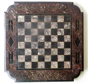 A slate table top game board with shaped corners, incised decorations including scrolls, in original