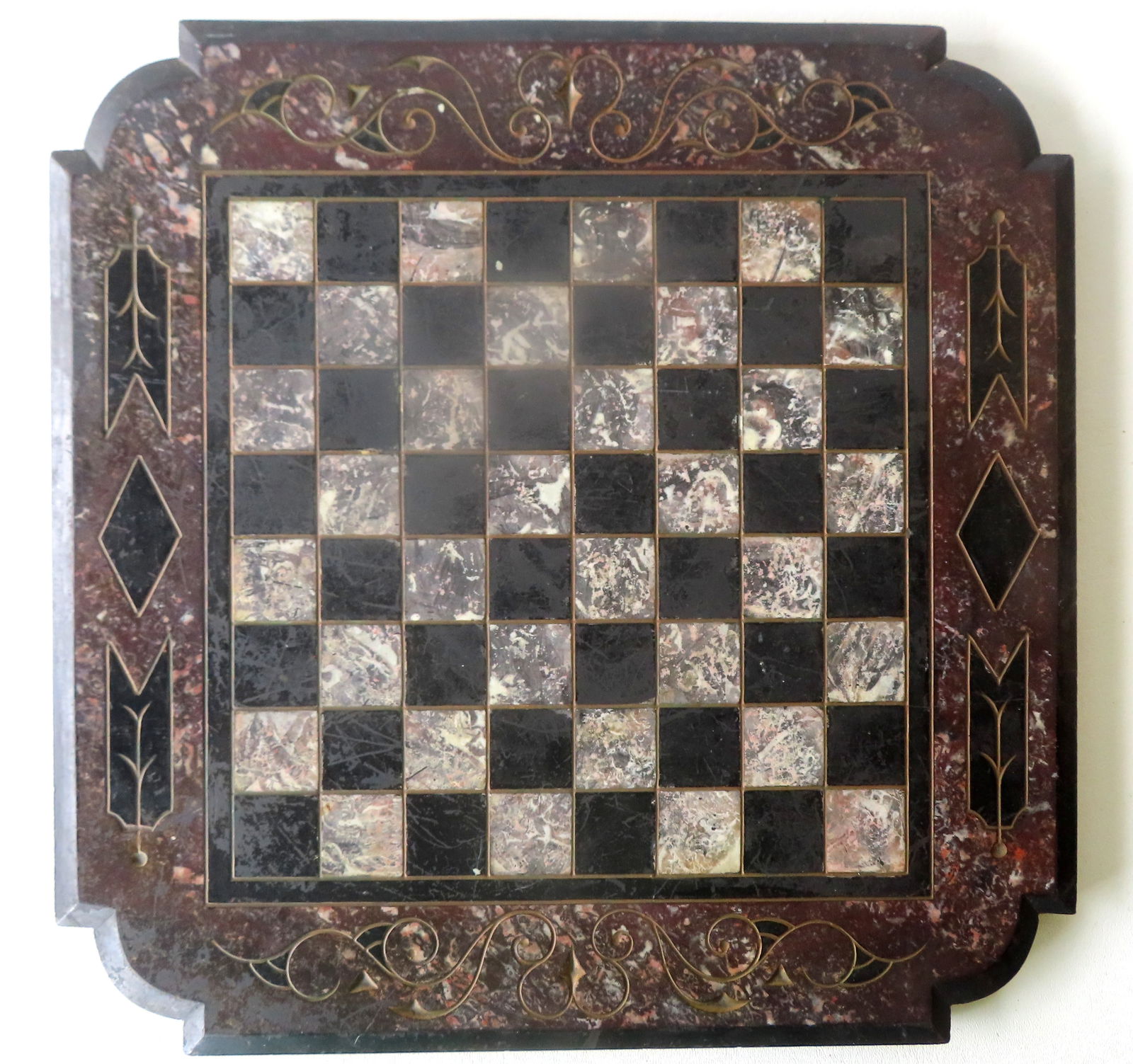 A slate table top game board with shaped corners, incised decorations including scrolls, in original: A slate table top game board with shaped corners, incised decorations including scrolls, in original black, white and gray paint. Circa 1870-80. Very good condition. Measures 16" square x 3/4" thick.