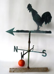 A silhouette copper crowing rooster weathervane mounted on arrow and with original directionals.