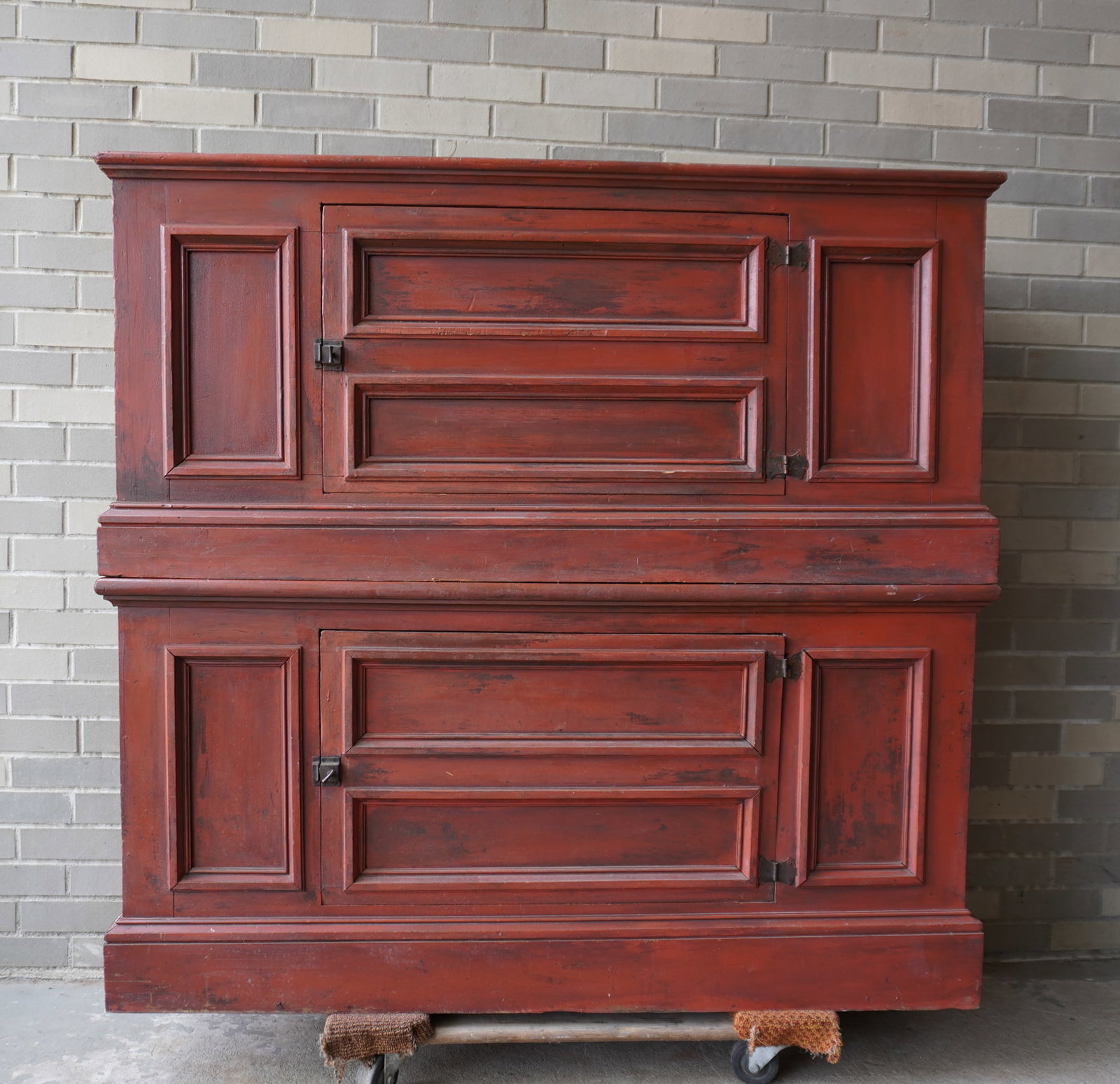 Two stackable primitive cupboards, each with a single door, paneled sides and front, molded base and: Two stackable primitive cupboards, each with a single door, paneled sides and front, molded base and in original red paint. Circa 1830-50. Total cupboards in stacked position, measures 51 1/2"W x 16 1