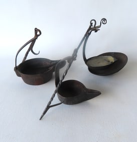 Three early iron fat burning lamps, 18th century, all with original hand forged iron hangers - one