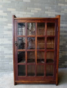A good Gustav Stickley oak bookcase #715, having a single door with 16 glass lights (4 x 4).