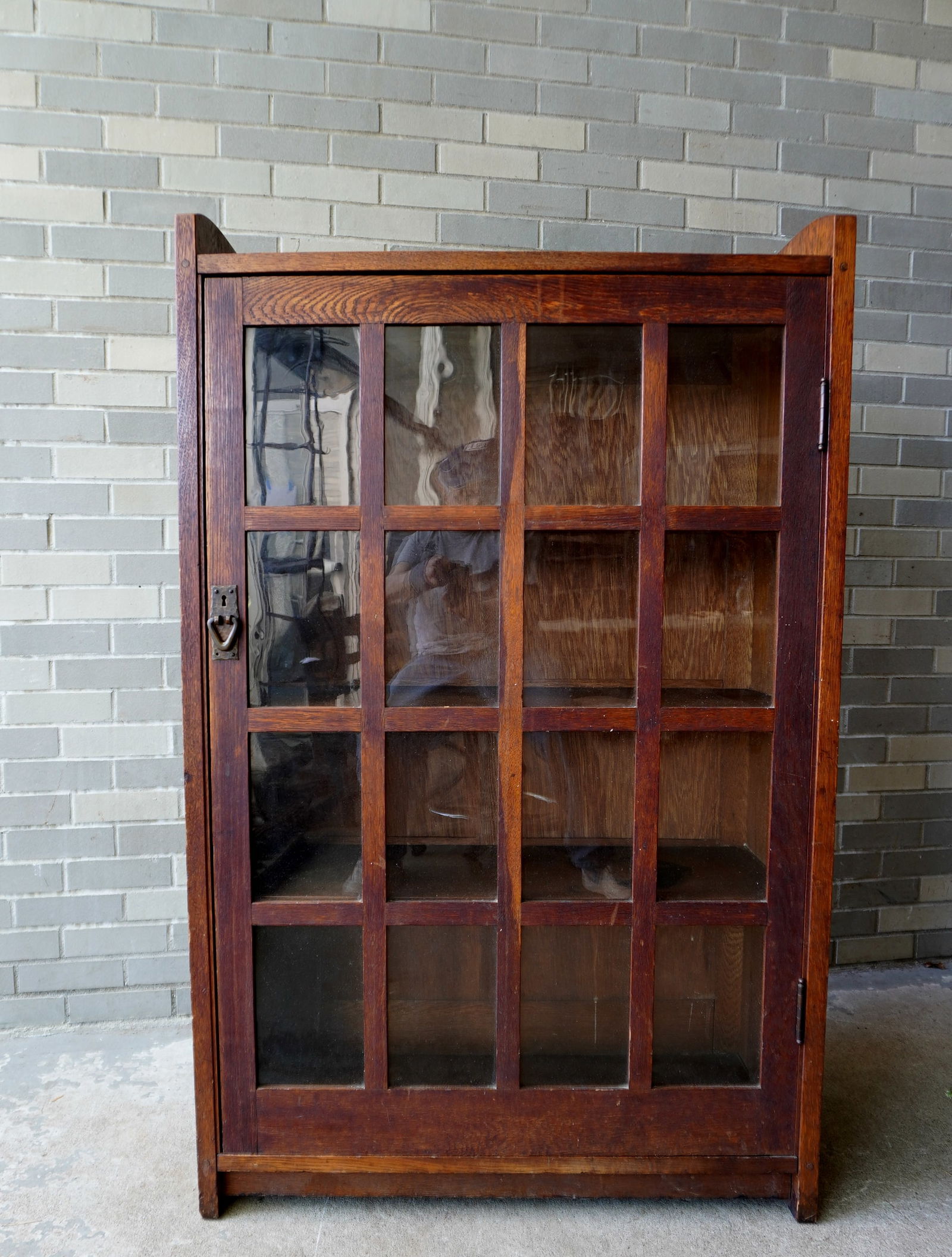 A good Gustav Stickley oak bookcase #715, having a single door with 16 glass lights (4 x 4).: A good Gustav Stickley oak bookcase #715, having a single door with 16 glass lights (4 x 4). Original finish, see through mortised construction, paneled back and Gustav Stickley label (see photos). Ve
