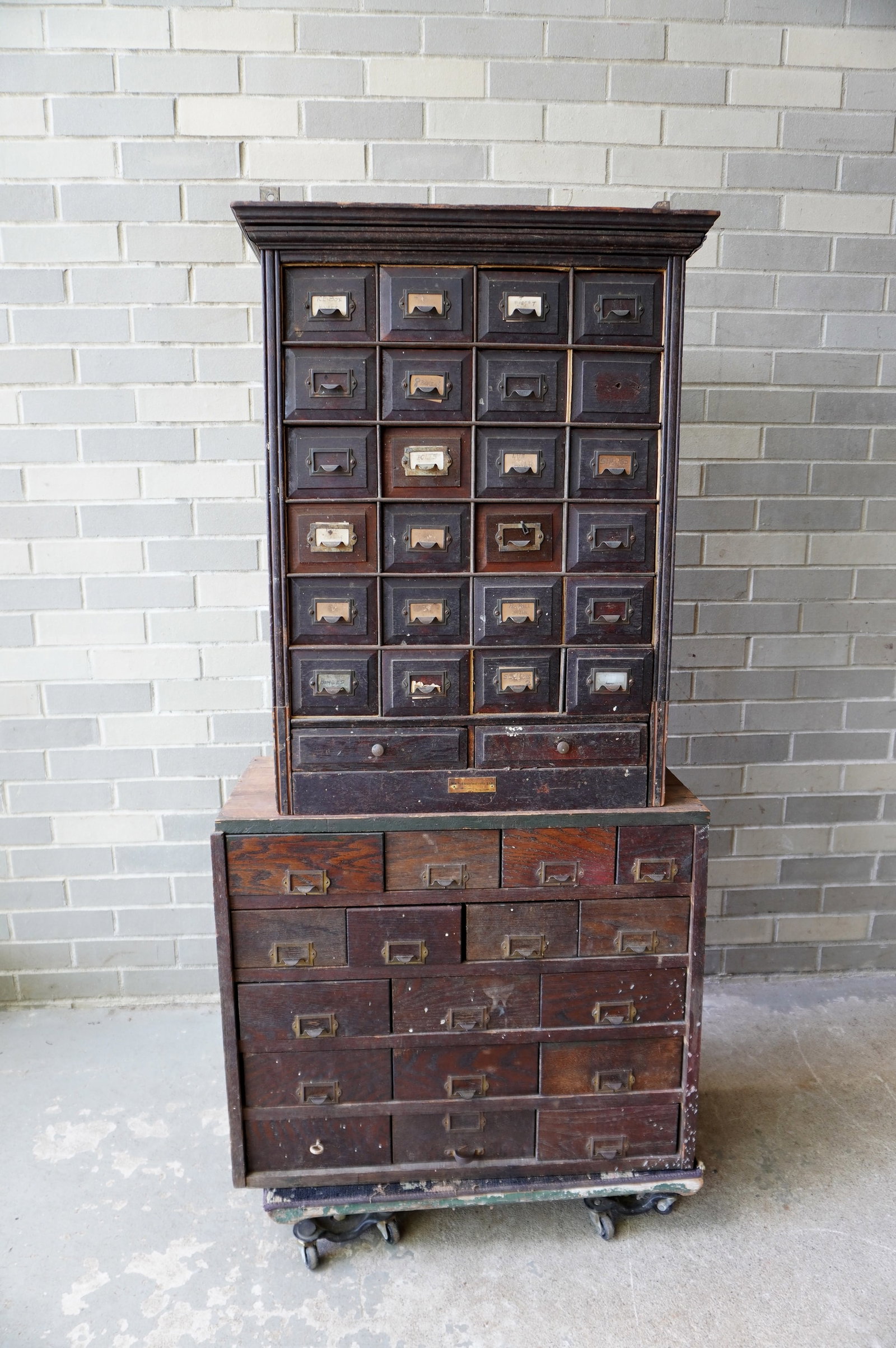 Two wooden utility file cabinets. The first with walnut construction including drawer fronts,: Two wooden utility file cabinets. The first with walnut construction including drawer fronts, galvanized metal drawer frames, 24 small drawers (4 x 6) over 2 long drawers - missing 1 pull - measures 2