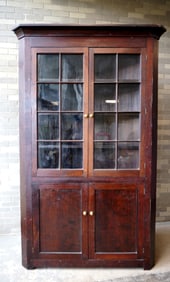A cherry 1 piece corner cupboard having 2 glass doors each with 8 glazed lights over 2 solid doors,