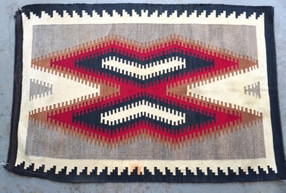 A good Navajo Eye Dazzler scatter rug, early 20th century. Some light staining, loose threads in one