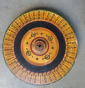 A vintage hand made double sided carnival gaming wheel in original paint, early to mid 20th century.