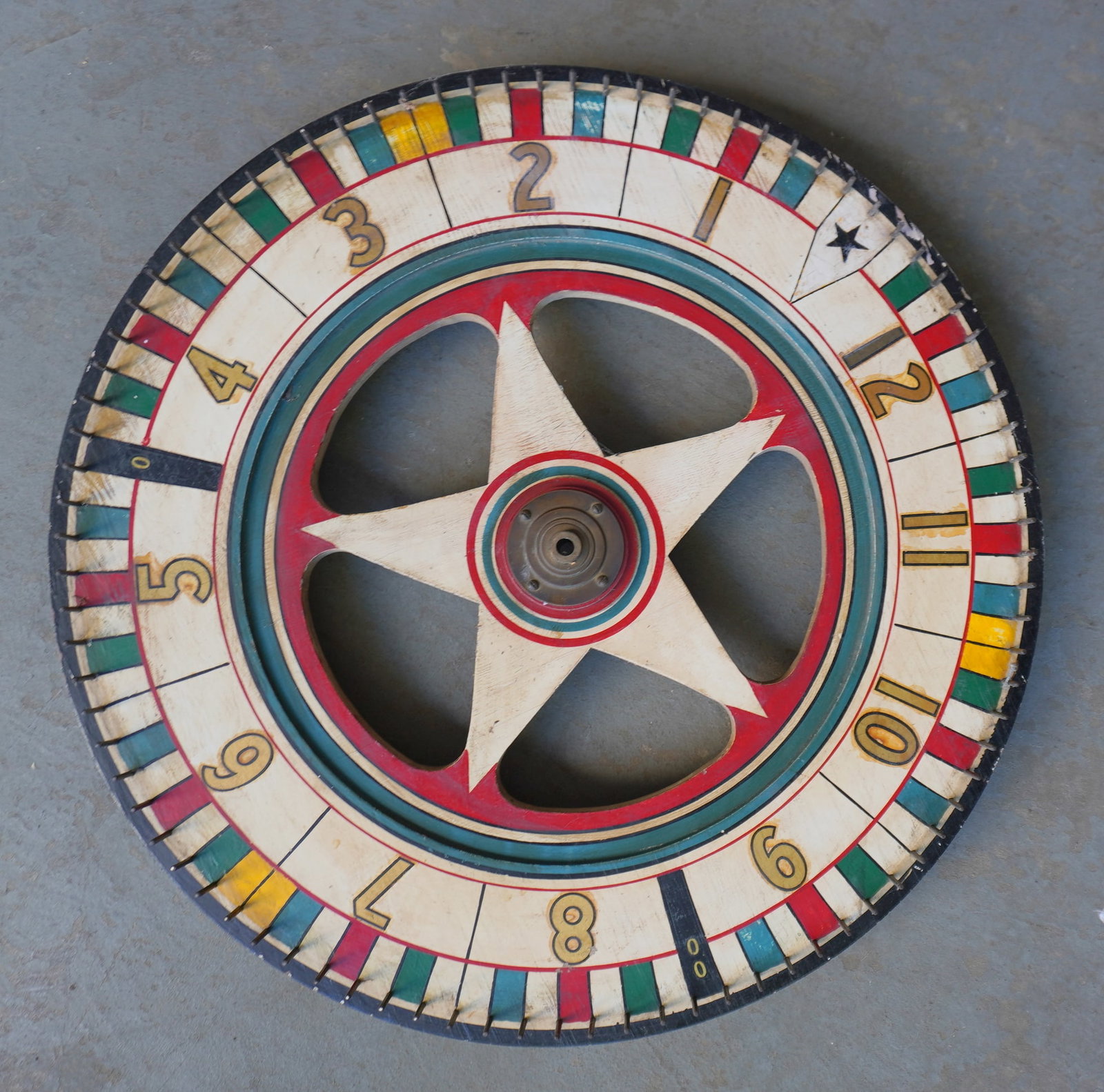 A vintage hand made double sided carnival gaming wheel in original paint, with a star shaped center,: A vintage hand made double sided carnival gaming wheel in original paint, with a star shaped center, early to mid 20th century. Some typical use wear, and overall in very good condition in working ord