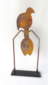 A cast iron carnival swivel shooting target in the form of a bird in original yellow paint - wear to