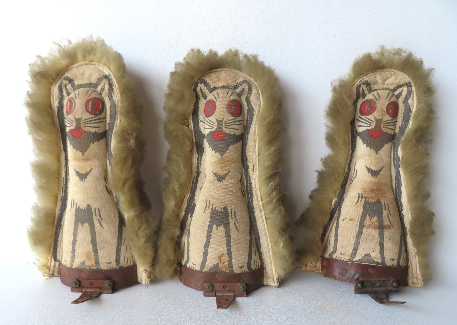 Three vintage canvas carnival knock down dolls in the form of cats, all with wooly hair, circa 1930.: Three vintage canvas carnival knock down dolls in the form of cats, all with wooly hair, circa 1930. One with tear in canvas, otherwise all in good condition. Each measures approximately 11 1/2"H. Pro