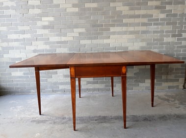 A Hepplewhite style cherry dining room table with long drop leaves and tapered legs - oval inlaid