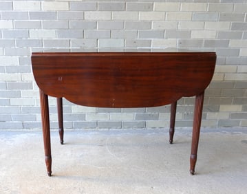 A Sheraton mahogany drop leaf table with reeded legs, and single dovetailed drawer with rosette