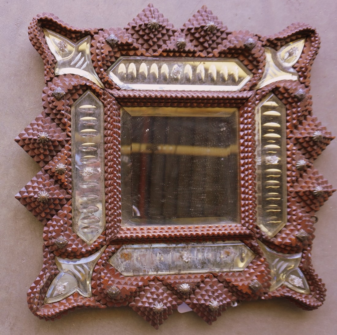 An unusual tramp art wall mirror - the central beveled mirror is surrounded by smaller decorative: An unusual tramp art wall mirror - the central beveled mirror is surrounded by smaller decorative mirrors, early 20th century. Some minor losses to the silver mirror backing, otherwise it is in very g