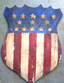 A hand carved wooden American shield with 13 stars, original red, white and blue paint, probably