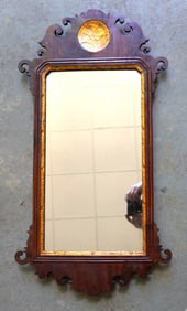 A Chippendale wall mirror with gold inset and having a crest with a circular hollow relief carving