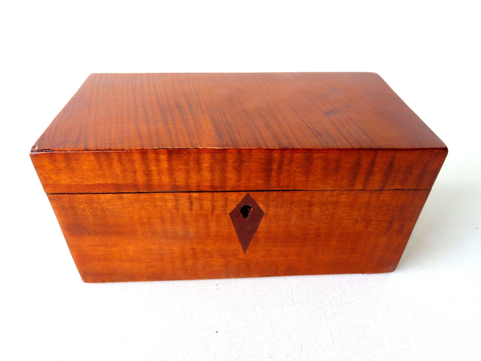 An American tiger maple tea caddy with 2 interior compartments with original lids. Original hasp and: An American tiger maple tea caddy with 2 interior compartments with original lids. Original hasp and lock, but lacking key. Very good condition, early to mid 19th century. Measures 4"D x 8"W x 4"H. Pr