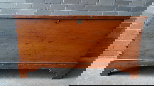 A refinished pine blanket box with interior till, dovetailed case, replaced strap hinges, mounted on