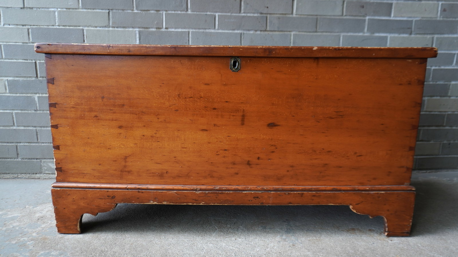 A refinished pine blanket box with interior till, dovetailed case, replaced strap hinges, mounted on: A refinished pine blanket box with interior till, dovetailed case, replaced strap hinges, mounted on original bracket base and in good overall condition. Measures 40 1/2"W x 18"D x 21"H. Provenance: F