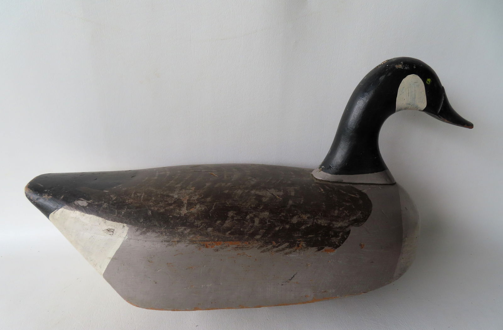 A good carved wooden goose decoy in original paint, solid 2 part body, early 20th century. Measures: A good carved wooden goose decoy in original paint, solid 2 part body, early 20th century. Measures 23"L x 9 1/4"W x 10 1/2"H. Very good condition. Provenance: From an Ulster County NY resident, downs