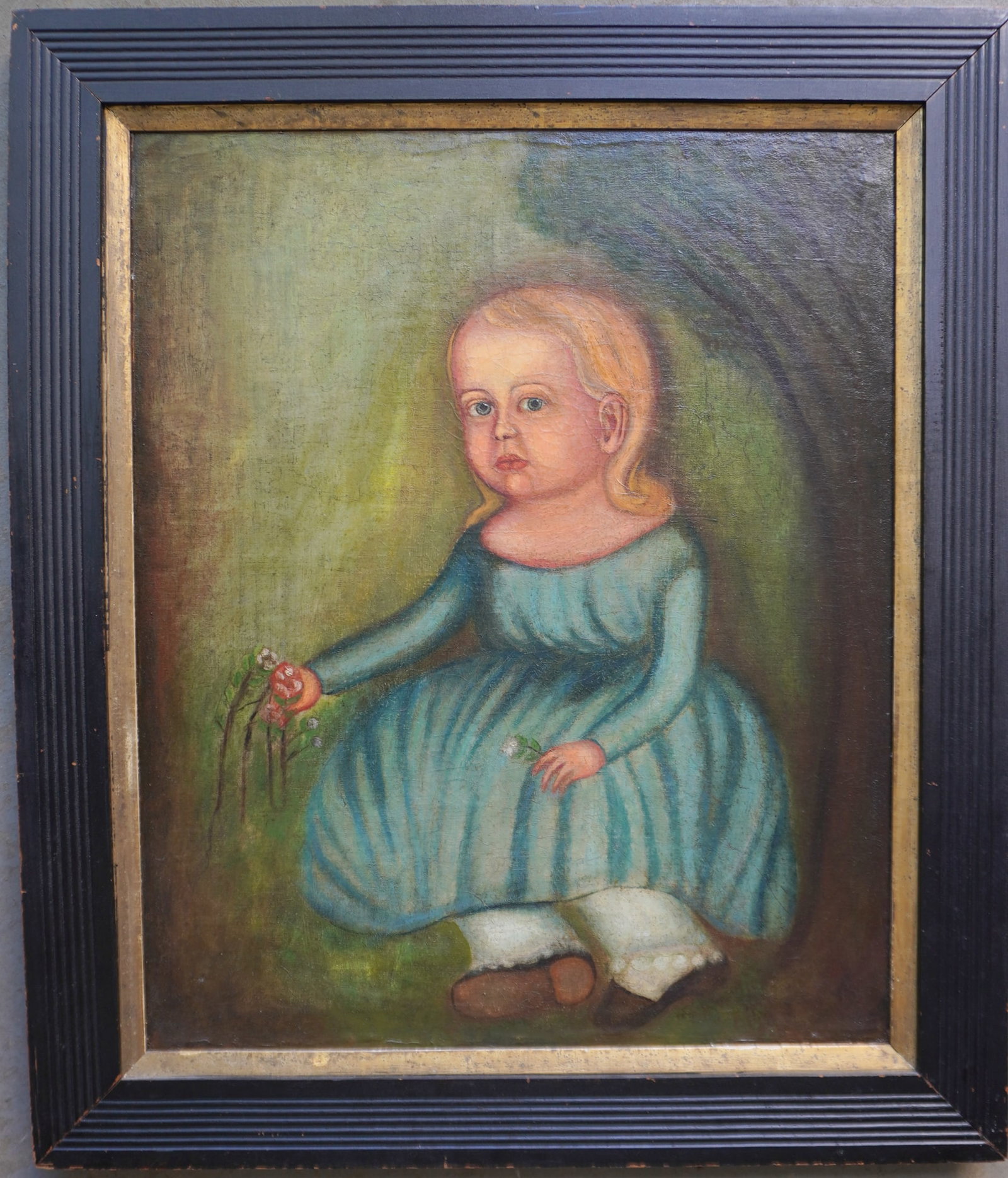 O/C Primitive portrait of child holding roses, early to mid 19th century, housed in a later wooden: O/C Primitive portrait of child holding roses, early to mid 19th century, housed in a later wooden frame. The painting has been restored (relined) and applied to a new stretcher. According to note on 