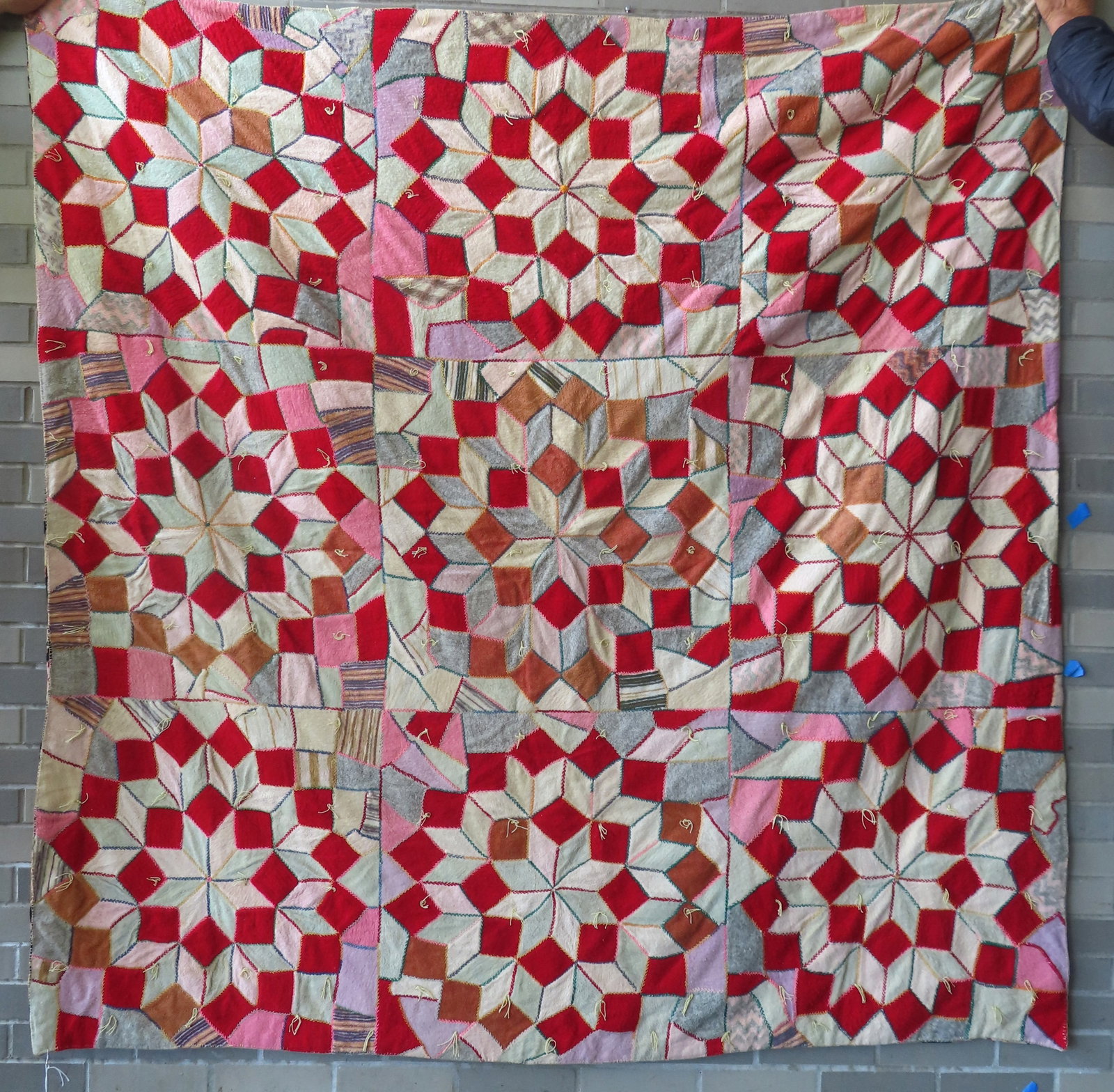 A late Victorian winter wool quilt, "Mystery Star" pattern but in Crazy Quilt style, hand sewn and: A late Victorian winter wool quilt, "Mystery Star" pattern but in Crazy Quilt style, hand sewn and tied to reverse with stuffed backing, early 20th century, measures 69" x 73". Very good condition.
