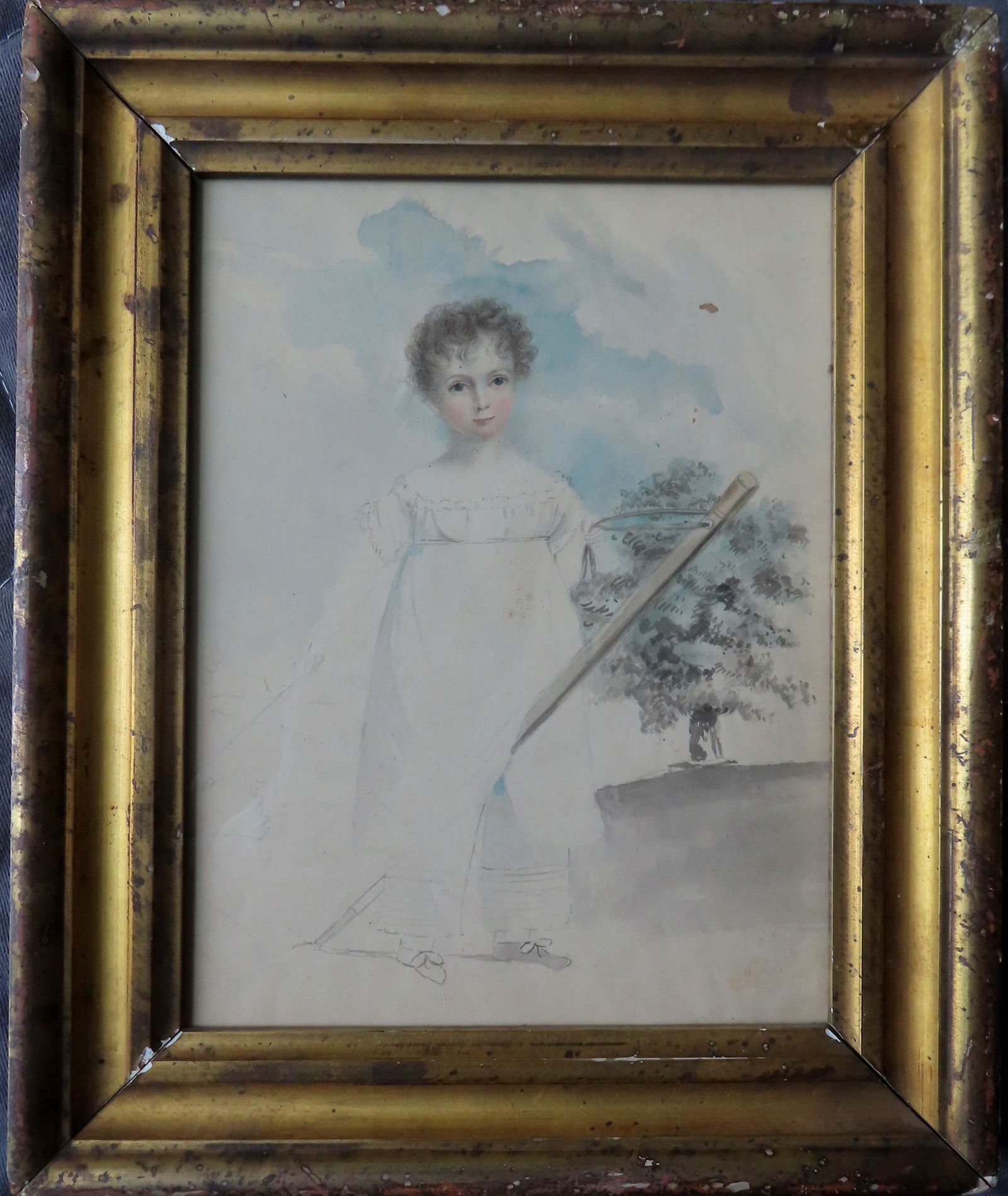 W/C Primitive portrait of young girl with riding toy, tree in background, circa 1850, housed in a: W/C Primitive portrait of young girl with riding toy, tree in background, circa 1850, housed in a same period lemon gold frame which may be original. Total frame size 9 1/2" x 11 3/4". The artwork in