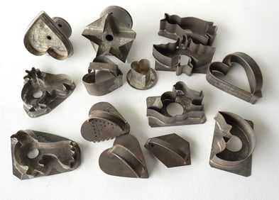 A grouping of 14 early tin figural cookie cutters including: Bat, hearts, star, cat, birds,
