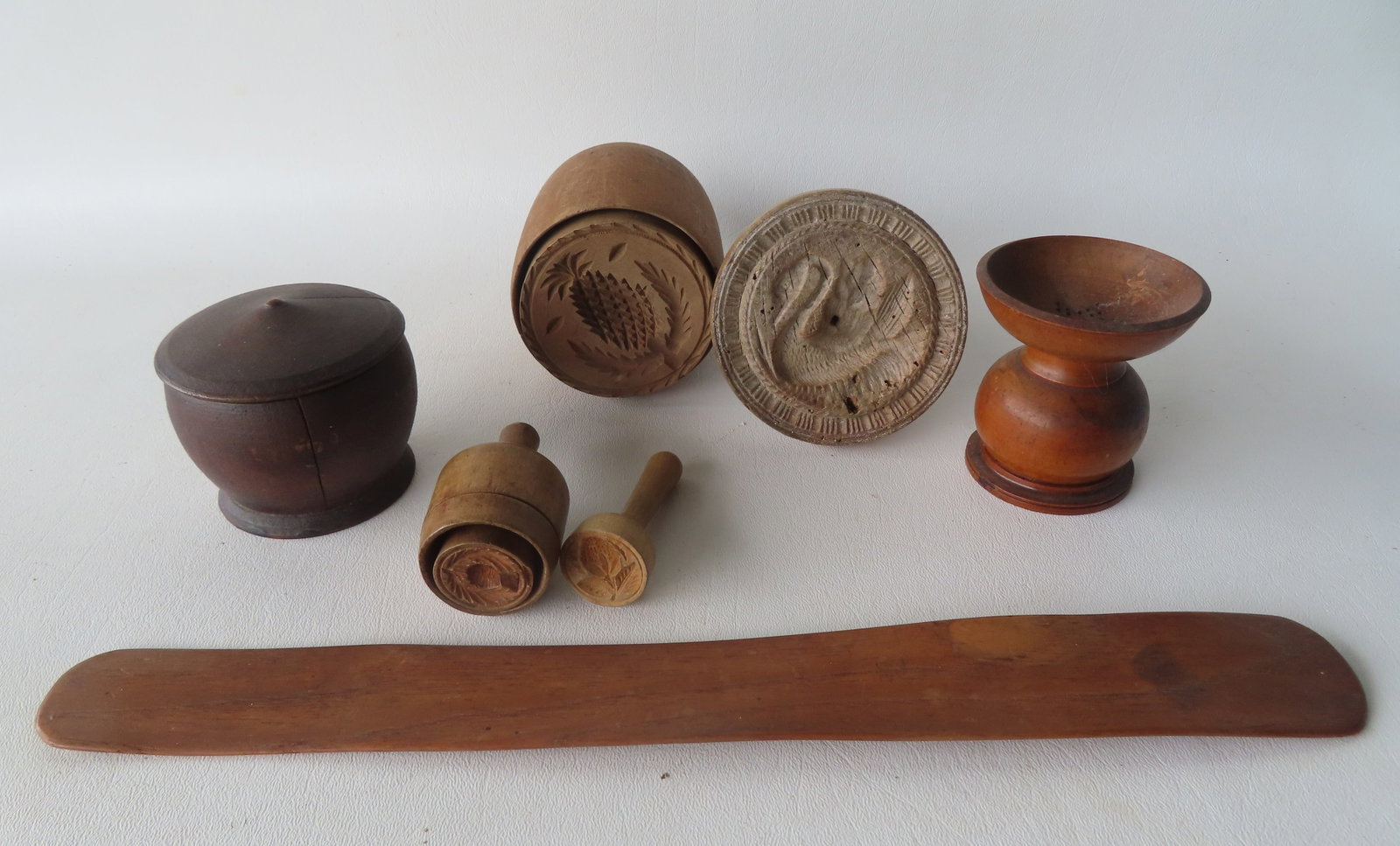 Grouping of country treenware including butter stamp of pineapple - mid to late 19th century, an: Grouping of country treenware including butter stamp of pineapple - mid to late 19th century, an earlier butter press of swan, 2 smaller late 19th century butter stamps, a treenware ink sander, a smal