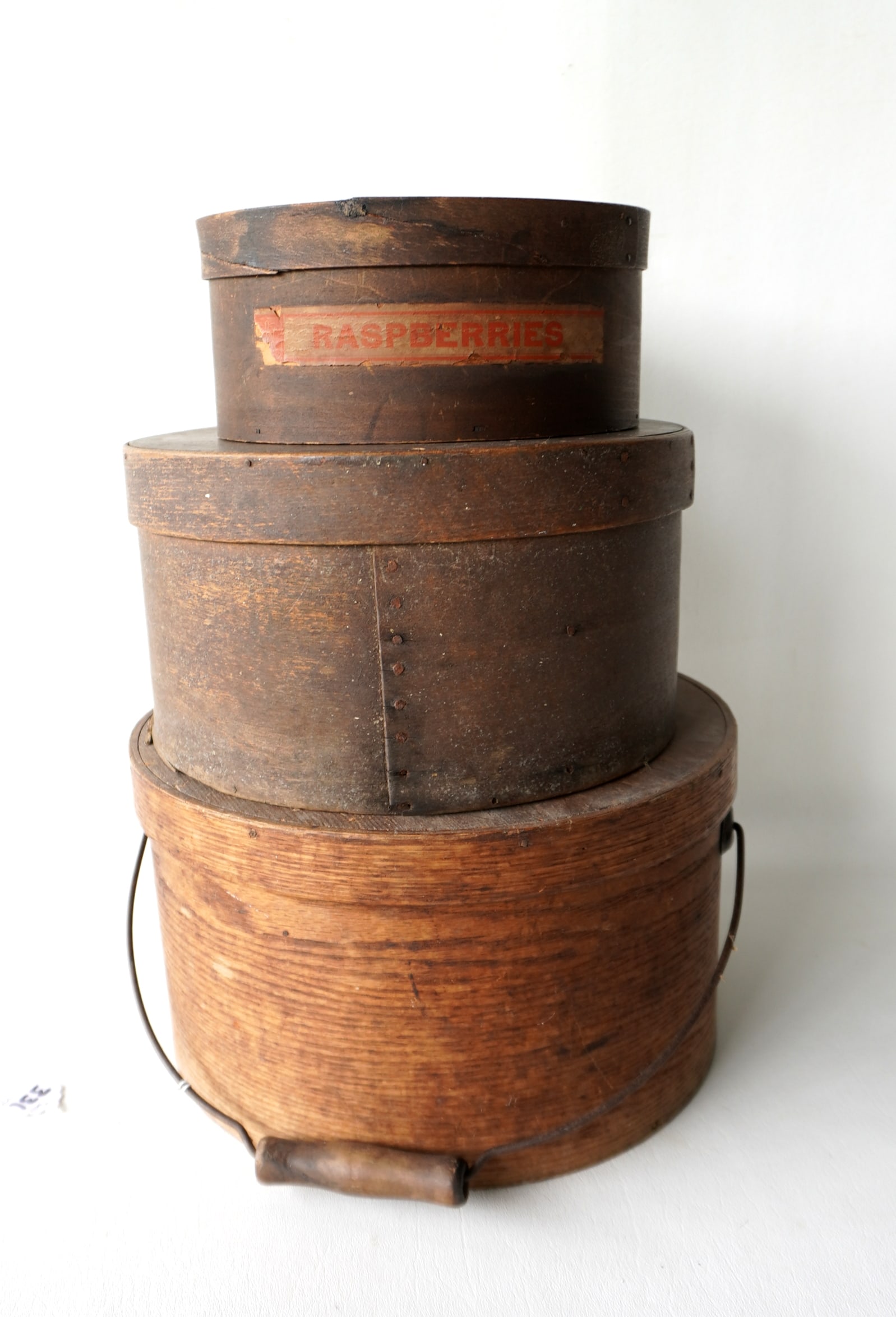 Three country pantry boxes including: The largest with wire and wood bale handle in old natural: Three country pantry boxes including: The largest with wire and wood bale handle in old natural finish, circa 1850 - 11 1/2" diameter x 6 1/2"H - very good condition; a round lidded box with applied c