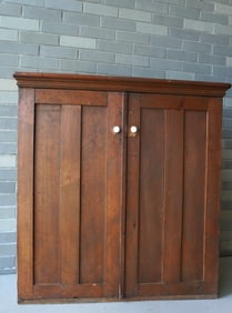 A narrow pine floor or wall hanging cupboard having 2 paneled doors and molded cornice, late 19th