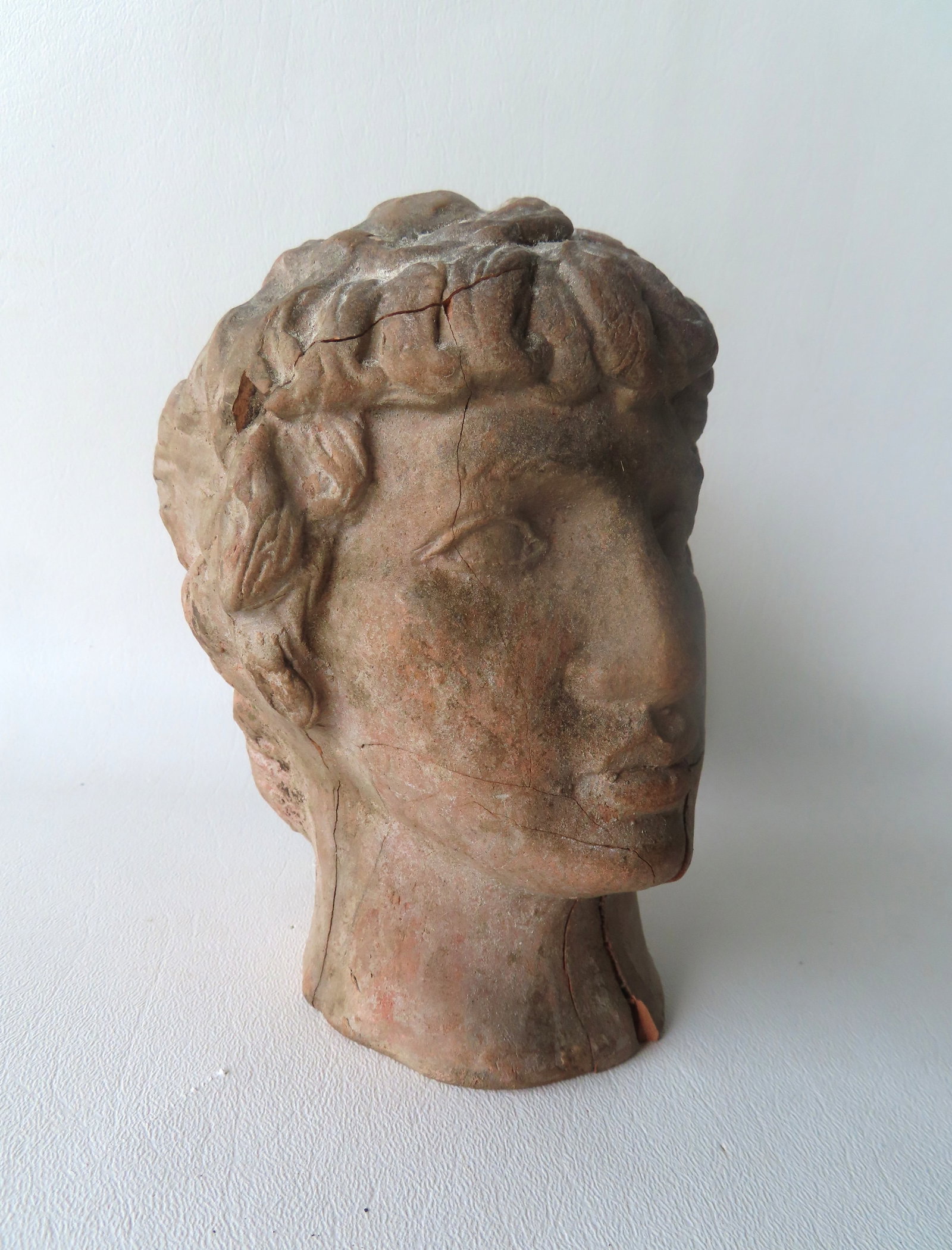 A classical early hollow terra cotta bust of a Roman or Greek gentleman, several cracks and repairs,: A classical early hollow terra cotta bust of a Roman or Greek gentleman, several cracks and repairs, especially the repairs on both sides of the face that start at the neck and extend into the chin ar