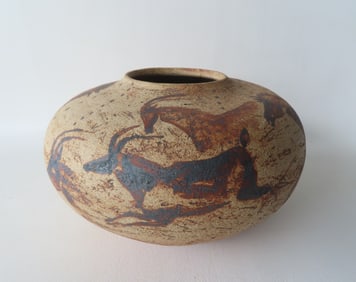 A pottery jar decorated in the ancient cave wall style with hand painted wild horses, antelope and