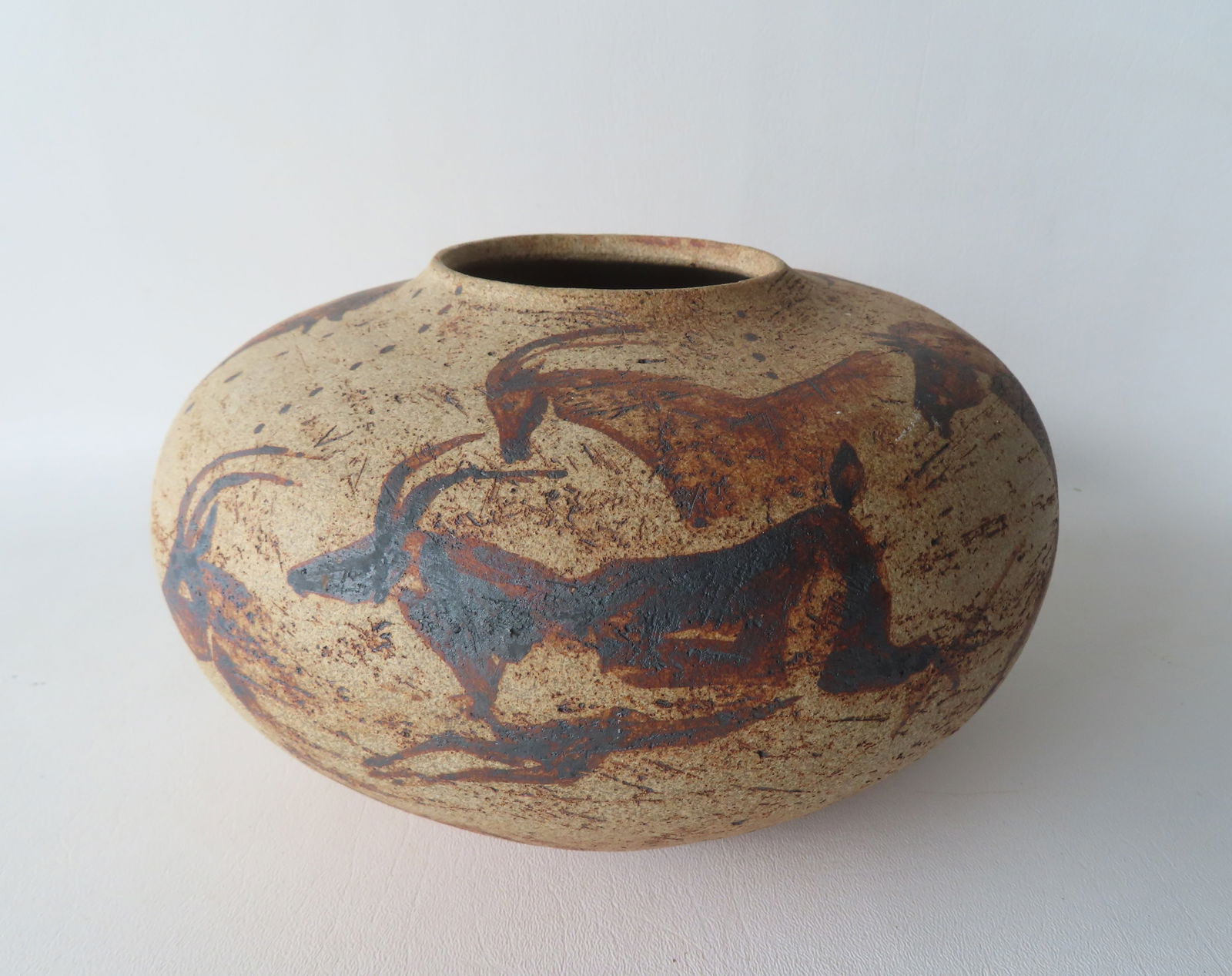 A pottery jar decorated in the ancient cave wall style with hand painted wild horses, antelope and: A pottery jar decorated in the ancient cave wall style with hand painted wild horses, antelope and steer, circa 1970-90 signed Nancy Steckel (Sharon Ct, 1932-2022). We have sold many articles over the