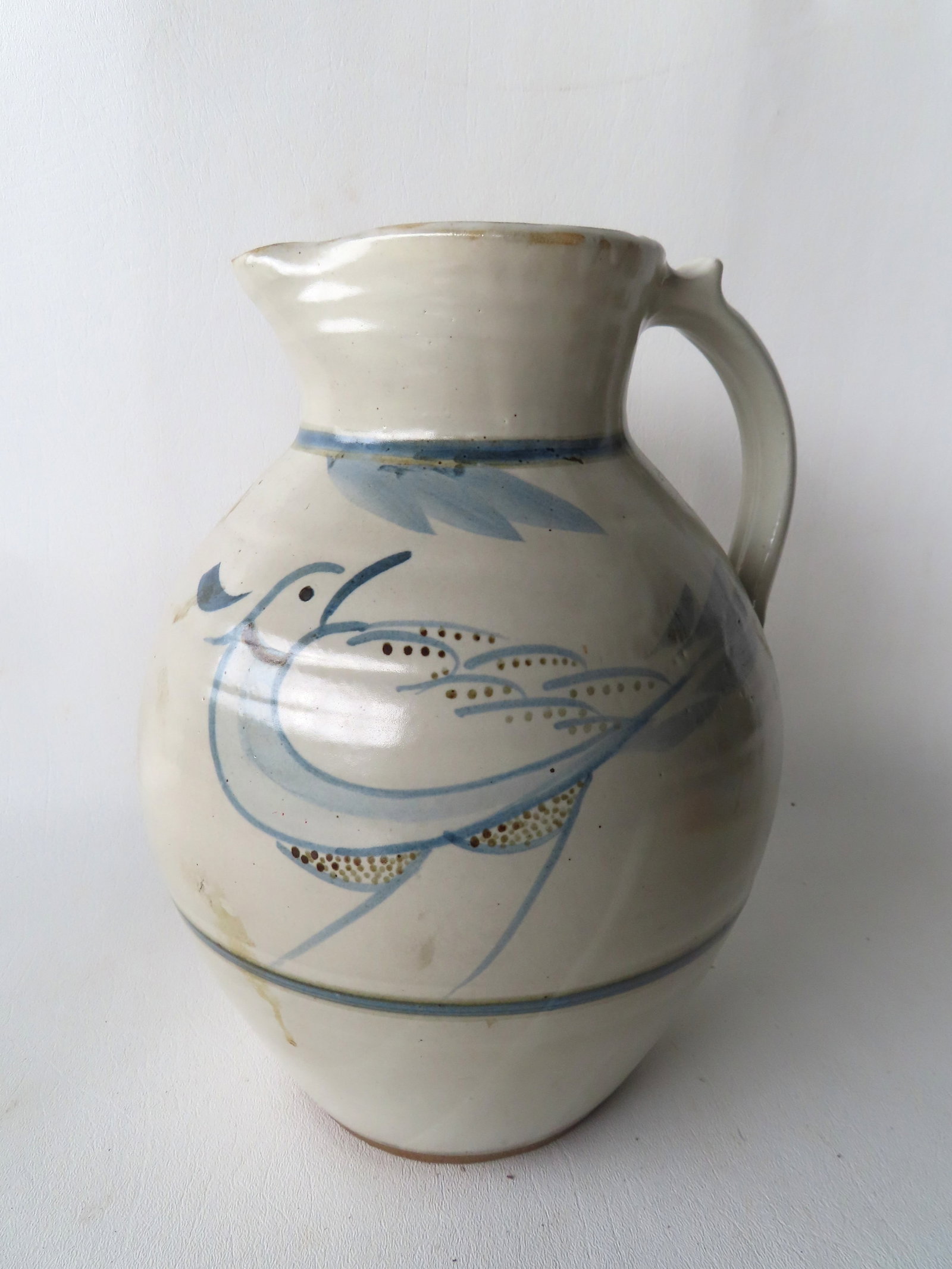 A stoneware pitcher, gray glaze and decorated with a cobalt blue bird on branch on both sides of: A stoneware pitcher, gray glaze and decorated with a cobalt blue bird on branch on both sides of pitcher, probably mid to late 20th century in very good condition with only slight stains. Measures app