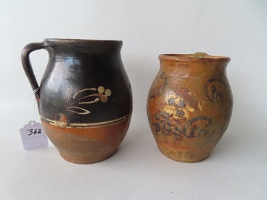 Two redware pitchers with unusual slip decorations but with extensive losses to glazing. The largest